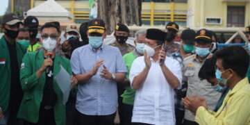 Wapresma Unand Dafiq Naskar bacakan tuntutan dalam aksi Tolak UU Cipta Kerja disaksikan oleh Kepala Disnakertrans Sumbar, Nasrizal di depan Kantor Gubernur Sumbar, Sabtu (1/5/2021). (Genta Andalas/Afdal Hasan)