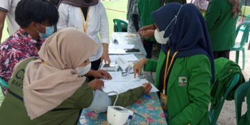 Mahasiswa KKN Unand Kelurahan Pisang melakukan pengecekan kesehatan gratis kepada masyarakat, Sabtu (21/8/2021). (Genta Andalas/Natasya Salsabilla Festy)