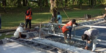 Beberapa orang pekerja sedang melakukan perbaikan jalan Gerbang-Bundaran Rektorat Unand pada Jumat (15/10/21). (Genta Andalas/ Natasya Salsabilla Festy)