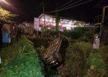 Sebuah mobil terbalik ke parit di Jalan Kampus Unand, Simpang Kampung Duri, Padang pada Minggu (6/3/2022). (Genta Andalas/Khoiratul Fitri Syahdia)