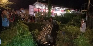 Sebuah mobil terbalik ke parit di Jalan Kampus Unand, Simpang Kampung Duri, Padang pada Minggu (6/3/2022). (Genta Andalas/Khoiratul Fitri Syahdia)