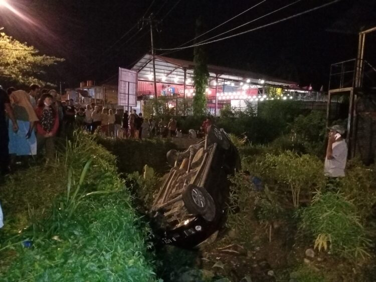 Sebuah mobil terbalik ke parit di Jalan Kampus Unand, Simpang Kampung Duri, Padang pada Minggu (6/3/2022). (Genta Andalas/Khoiratul Fitri Syahdia)