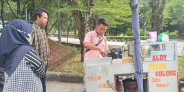 Pedagang Kaki Lima (PKL) yang sedang melayani pembeli dari kalangan mahasiswa di lingkungan bank sentral Universitas Andalas (Unand), Rabu (2/3/2022)