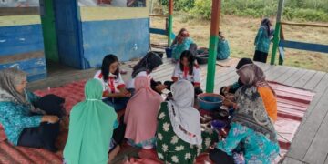 Mahasiswa KKN Kebangsaan dan Kelompok Ibu Pemberdayaan Kesejahteraan Keluarga Desa Manuntung membuat Abon Iwak Haruan, Jumat (19/8/2022). (Genta Andalas/Dok. Pribadi)