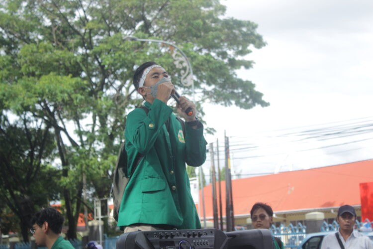 Salah seorang mahasiswa peserta aksi menyampaikan orasi, Senin (26/09/2022). (Genta Andalas/Fatiza Khaira)
