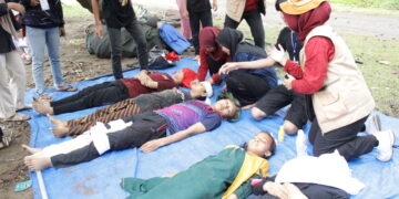 Peserta kader melakukan simulasi penanganan pasca bencana gempa bumi dan tsunami bersama mahasiswa Program Studi Profesi/Ners Fakultas Keperawatan Unand di Pantai Kampung KB, Parupuk Tabing, Padang pada Jumat (2/12/2022). (Genta Andalas/Fatiza Khaira)