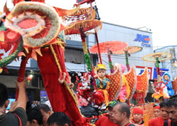 Potret seorang anak menaiki Sipasan pada arak-arakan Festival Cap Go Meh di Kampung Pondok, Kota Padang, Minggu (5/2/2023). (Genta Andalas/Lusi Agustia)