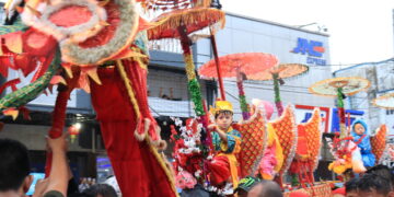 Potret seorang anak menaiki Sipasan pada arak-arakan Festival Cap Go Meh di Kampung Pondok, Kota Padang, Minggu (5/2/2023). (Genta Andalas/Lusi Agustia)