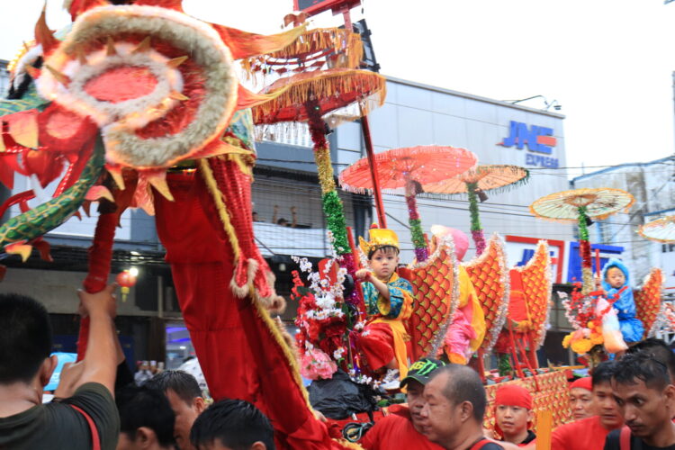 Potret seorang anak menaiki Sipasan pada arak-arakan Festival Cap Go Meh di Kampung Pondok, Kota Padang, Minggu (5/2/2023). (Genta Andalas/Lusi Agustia)