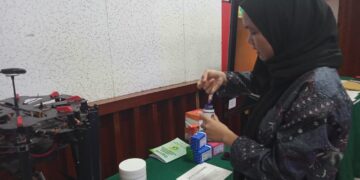 Salah seorang pengunjung yang mencoba inovasi tinta organik dari gambir pada acara Dies Natalis UNAND di Convention Hall UNAND pada Rabu (13/09/2023). (Genta Andalas/Atika Liutami Sadri)