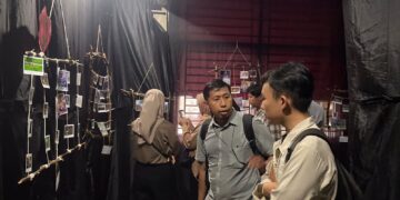 Para pengunjung sedang melihat berbagai foto yang dipamerkan  (Genta Andalas/Nabila Annisa)