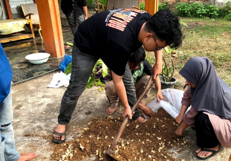 Proses pencampuran bahan baku pupuk organik kotoran ayam petelur dengan cairan EM4 (Dok.Pribadi)