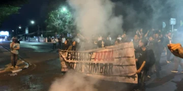 6. Massa aksi membentangkan spanduk bertuliskan “evaluasi total polda sumbar” sebagai respon penembakan water canon, Senin (21/4/2025)
(Oktavia Ramadhani