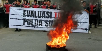 Massa aksi evaluasi 100 hari kerja Kepala Kepolisian Daerah Sumatera Barat melakukan demonstrasi membakar ban di depan kantor Polda Sumbar, pada Senin (21/4/2025) ( Oktavia Ramadhani)