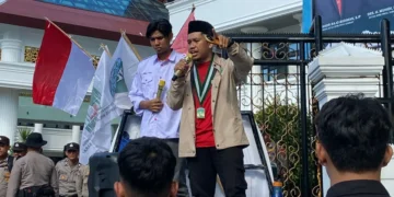 Ketua Umum PW KAMMI Sumbar, Jeni Mandala Saputra, melakukan orasi di depan gedung DPRD Sumatera Barat, Selasa (29/4/2025)  (Jovina Naila)