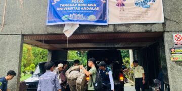 Relawan mengangkut perlengkapan kebutuhan darurat di Posko Tanggap Darurat Bencana Universitas Andalas pada Jumat (28/11/2025) (Genta Andalas/Zaki Latif)