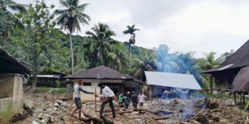 Warga membersihkan sisa material banjir di sekitar rumah mereka di kawasan Batu Busuk, Sabtu (28/12/2025). (Sabila Hayatul Dhi’fa/Genta Andalas)